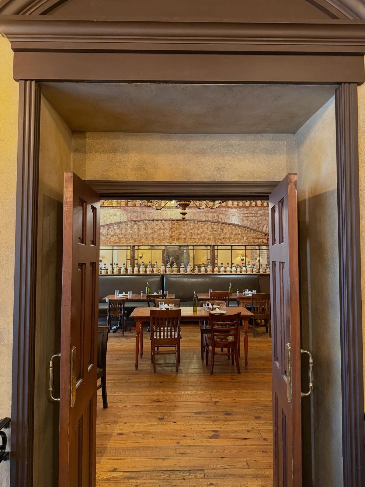 Double doors opening onto the brick-walled dining room